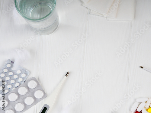 Wallpaper Mural a glass of water, pills, thermometer, paper napkins on white wooden background, Top view, copy space. Medicine concept photo. High angle view, flat lay Torontodigital.ca