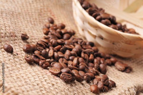 Close-up of coffee beans with a wicker basket on a burlap