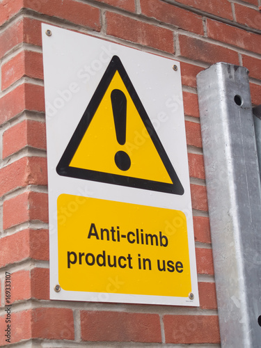 Description: Anti vandal, anti climb paint (a non-drying tar-like paint substance) applied to the top of a metal gate with accompanying warning sign.