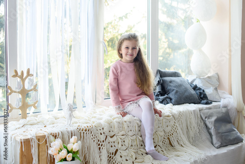 Cute little girl at home at window