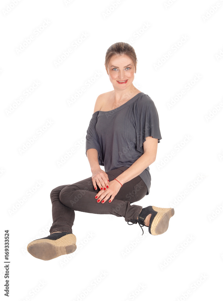 Young woman sitting on floor and smiling Young woman sitting on floor and smiling