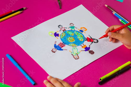 Kids draws with pencils and markers peace in the world. Child drawing the friendship of the peoples of the planet.