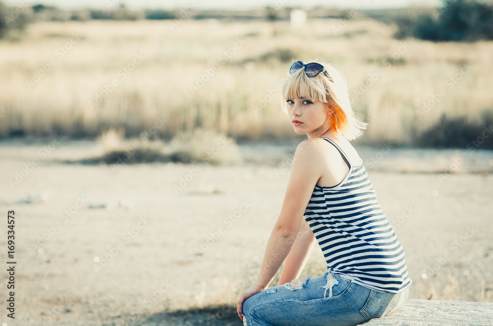 Rural girl in jeans and a striped t-shirt outdoors Rural girl in jeans and a striped t-shirt outdoors