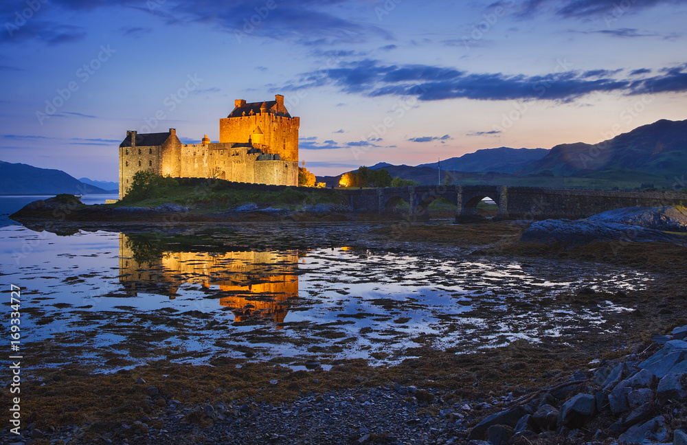 Eilean Donan Castle at Kyle reflecting itself into the water of Loch Duich and loch Alsh, during evening low tide.