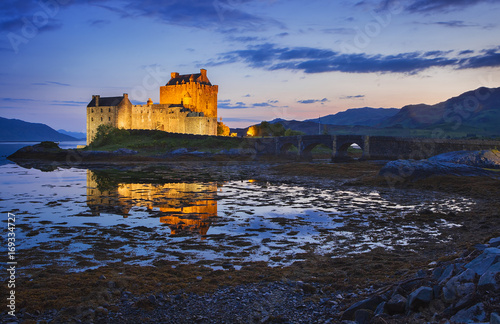 Eilean Donan Castle at Kyle reflecting itself into the water of Loch Duich and loch Alsh, during evening low tide.