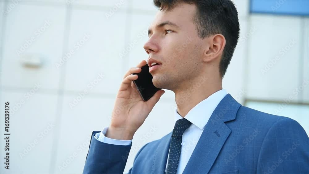 young european businessman talking mobile phone. close up young european businessman talking mobile phone. close up