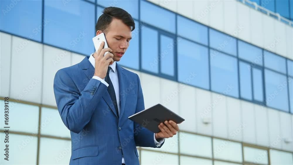 angry businessman looks at statistics in tablet and yells at employees on the phone angry businessman looks at statistics in tablet and yells at employees on the phone