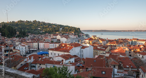 Sunlit Red Roofs of the Town Piran, Slovenia. View from Above at Sunrise.