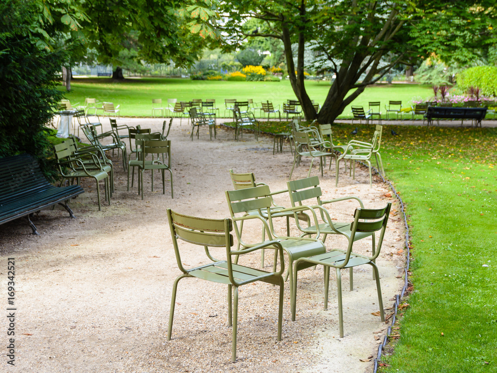Quiet morning in the Luxembourg garden with typical metallic chairs of the public gardens of Paris scattered along the walkways.