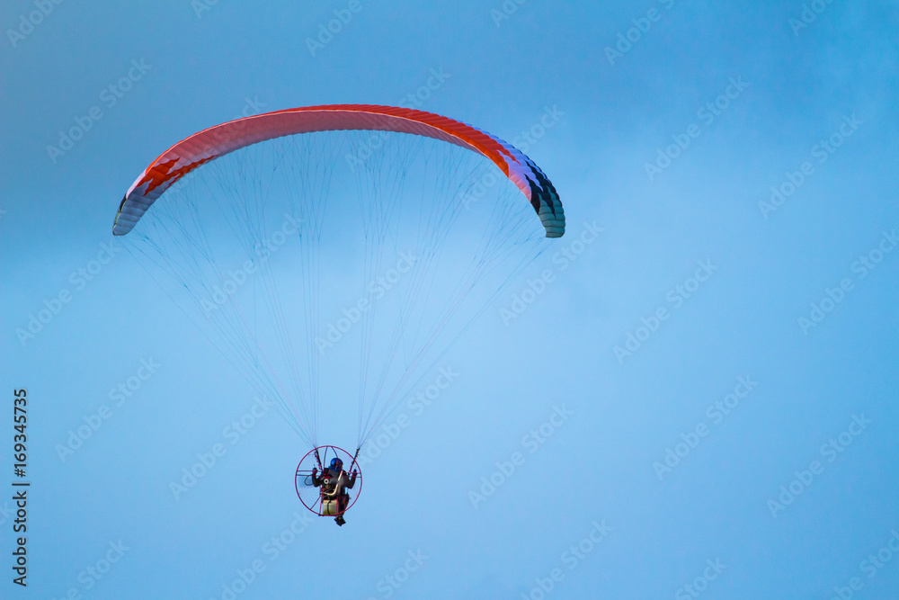 A man is flying on a paraglider in the sky A man is flying on a paraglider in the sky