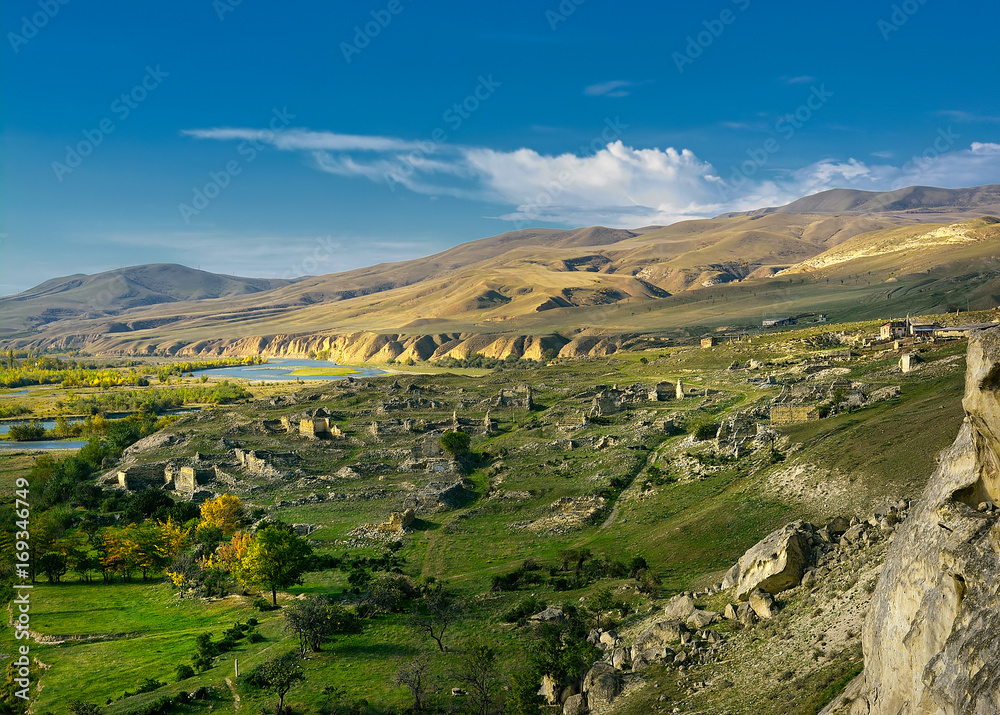 panorama of the green valley in mountains in bright sunny day, in the distance proceeds the river