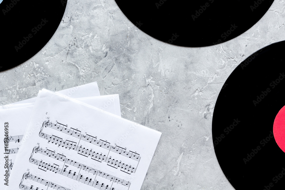 Fotografie dj work set with notes and vynil records on stone background top view