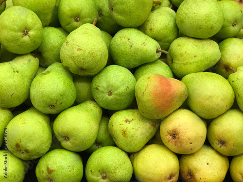 Green and Yellow Pears on Display in a Market Produce Bin