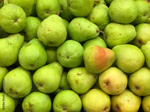 Photos Green and Yellow Pears on Display in a Market Produce Bin