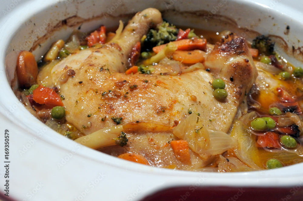 Chicken and vegetables slow cooking in a stoneware Chicken and vegetables slow cooking in a stoneware