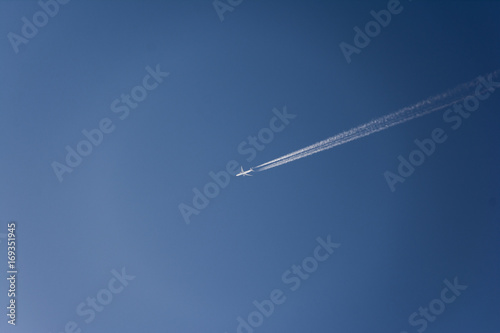 Airplane flying high in the sky with vapor trails