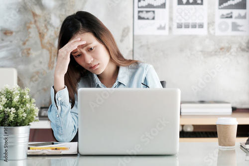 Businesswoman looking at laptop computer with stressed face at desk office, business situation, office lifestyle photo