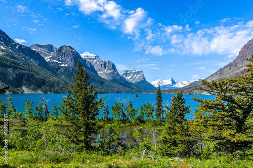 Spring at Saint Mary Lake - A panoramic view of high clouds passing over blue Saint Mary Lake and its surrounding steep mountains in Glacier National Park, Montana, USA. photo