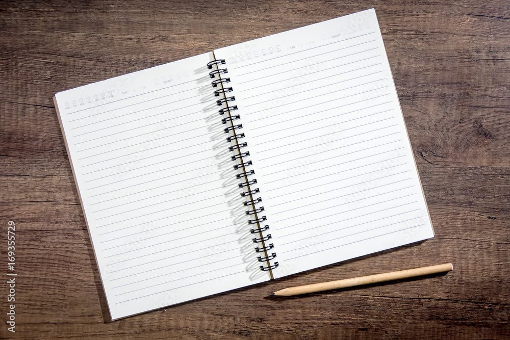 Top view notebook paper on wooden background. Concept for business and education. Top view notebook paper on wooden background. Concept for business and education.