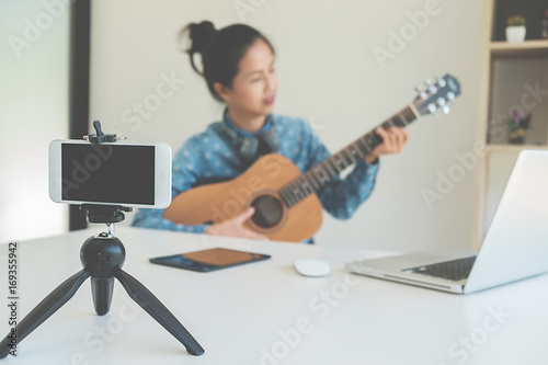 Young female blogger with smartphone recording video at home. beauty and technology concept