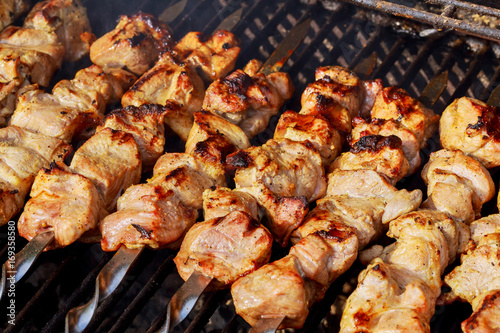 Marinated shashlik preparing on a barbecue grill over charcoal. Shashlik or Shish kebab
