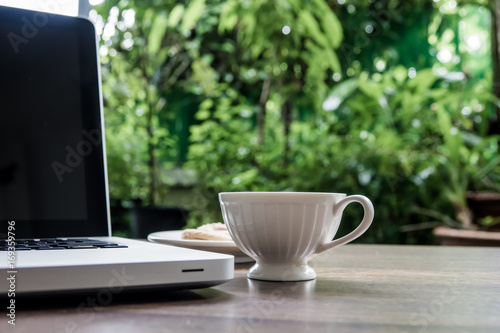 Top view home office table with laptop, coffee and cookie on wooden table. Modern office top view at home. New life style. Concept : business and office.