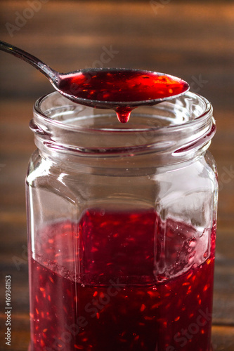 Homemade jam with raspberry on the wooden table, selective focus