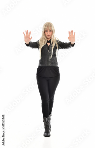 full length portrait of blonde girl wearing black leather outfit, standing pose on white background.