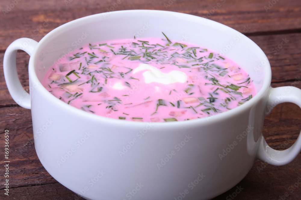 Popular spring cold soup okroshka with yoghurt. Okroshka in a bowl on wooden table. Selective focus Popular spring cold soup okroshka with yoghurt. Okroshka in a bowl on wooden table. Selective focus
