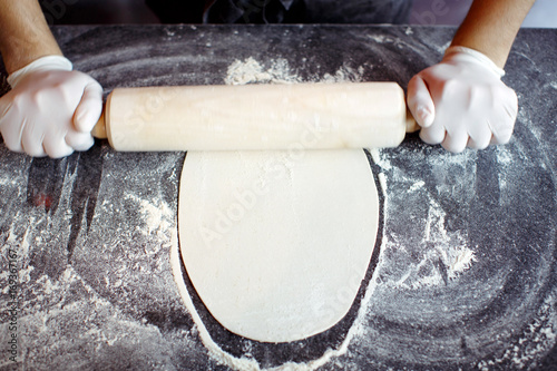 Crop chef rolling dough photo