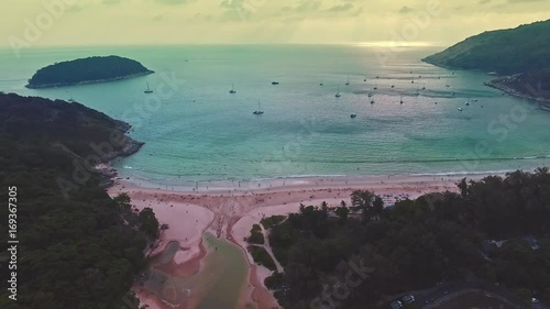 Aerial. Silent tropical beach, flying close above a tropical sandy beach and waves, beautiful view from the air shot over an Indian ocean deserted beach. Blue sea, sky, white clouds.