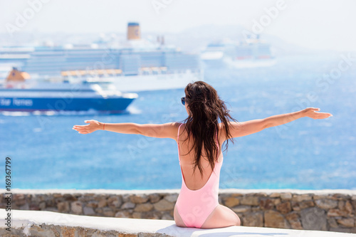 Young beautiful woman on the beach background big cruise ship.