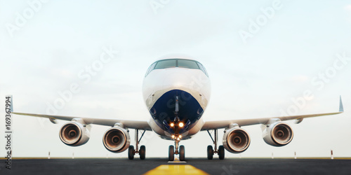 White commercial airplane standing on the airport runway at sunset. Front view of passenger airplane is taking off. Airplane concept 3D illustration.