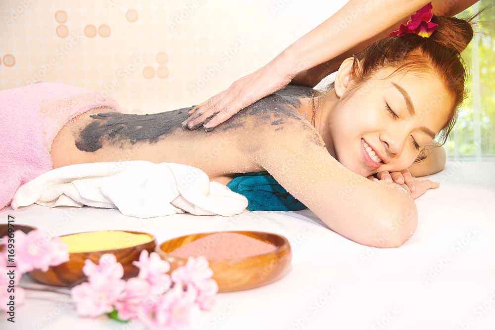 Spa therapist applying scrup salt and Charcoal on back woman Spa therapist applying scrup salt and Charcoal on back woman