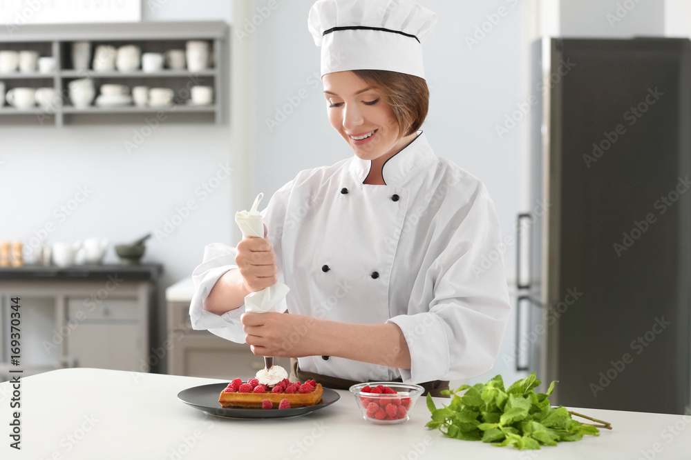 Female chef decorating dessert in kitchen Female chef decorating dessert in kitchen