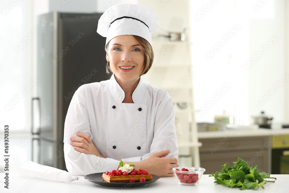 Female chef with tasty dessert in kitchen Female chef with tasty dessert in kitchen
