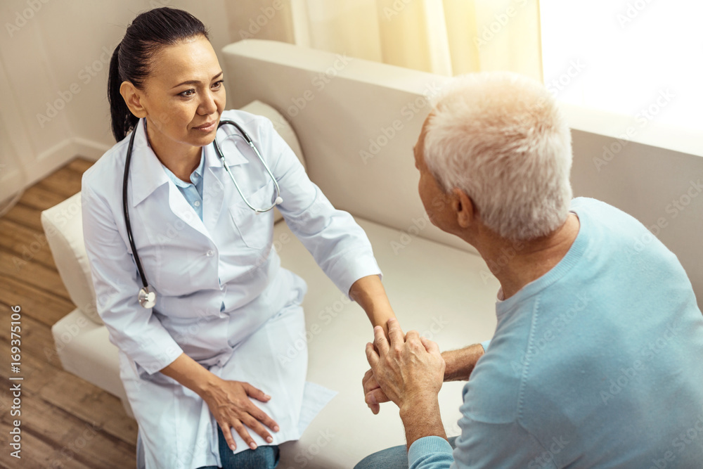 Obraz premium Nice elderly patient holding his nurses hand