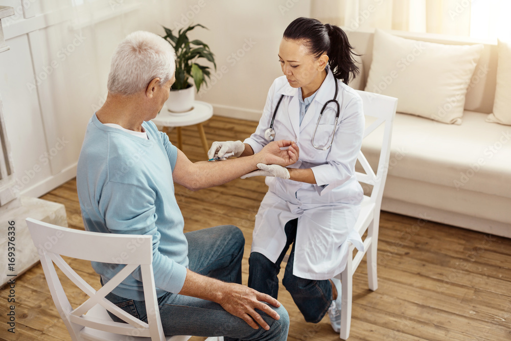 Obraz premium Nice serious nurse concentrating on her job