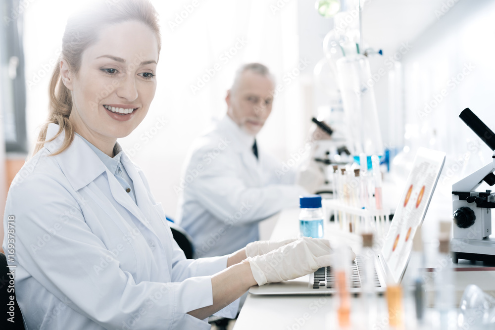 Positive delighted blonde looking at set with test tubes Positive delighted blonde looking at set with test tubes