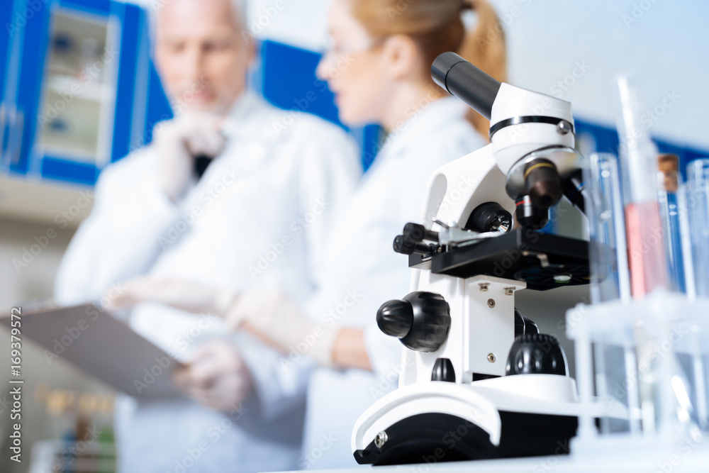 Close up of microscope that standing on the foreground Close up of microscope that standing on the foreground