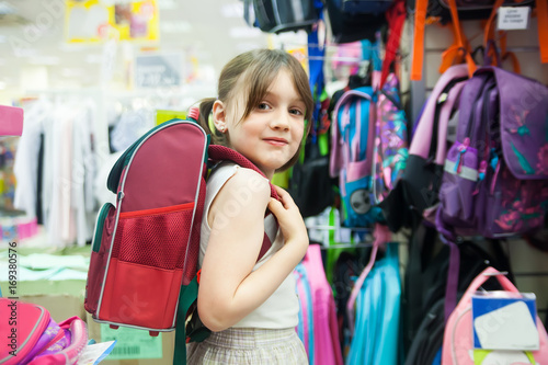  girl in store choosing briefcase for school.