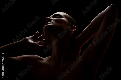 Foto aroused woman posing sensually holding head up on black background