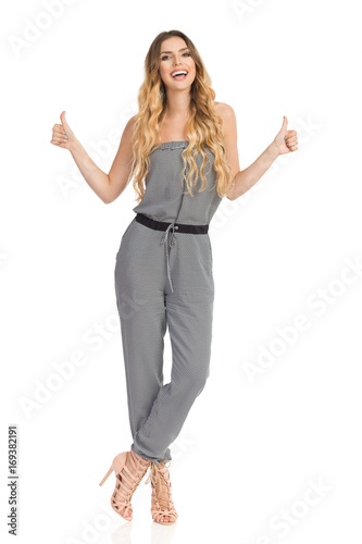 Talking Young Woman In Jumpsuit Is Showing Thumbs Up