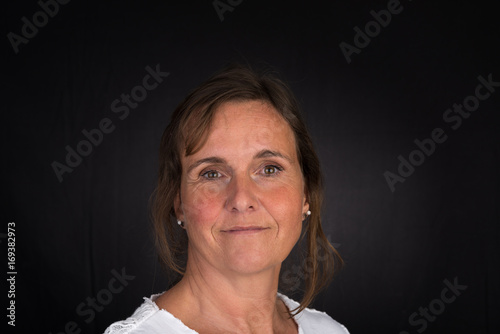 portrait of candid attractive mid-aged caucasian female adult - studio shot in front of dark background