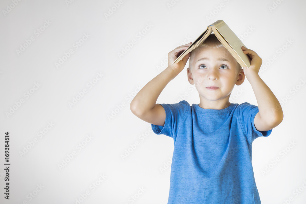 Portrait of little smiling schoolboy with book. Cheerful smiling little kid. School concept. Portrait of little smiling schoolboy with book. Cheerful smiling little kid. School concept.