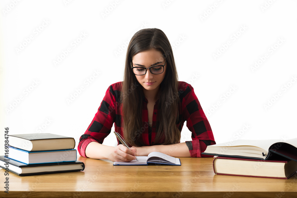 Attractive caucasian girl studying for her exams at home, education concept on white background Attractive caucasian girl studying for her exams at home, education concept on white background