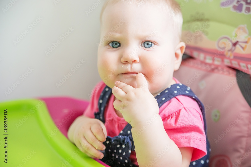 The baby is 7 months eats in a children's chair. The baby is 7 months eats in a children's chair.