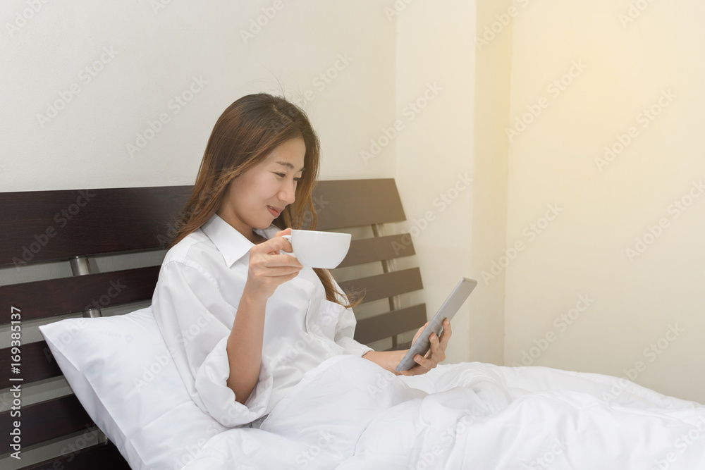 girl using a tablet and drinking coffee girl using a tablet and drinking coffee