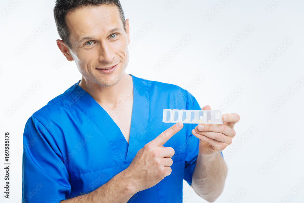Mature practitioner posing with pills organizer Mature practitioner posing with pills organizer