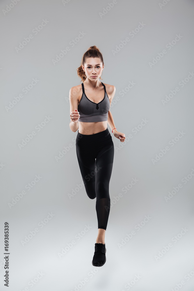 Full length portrait of a young woman in sportswear running